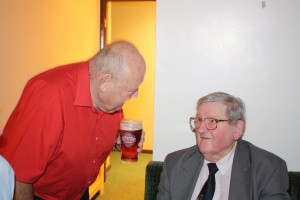 'That will cost you a pint Mike'. Colin Dobson, well known on trumpet with Billy "Wakey, Wakey" Cotton Band) talking to Mike Barry (left) at Farnborough Jazz Club. 26th September 2014 Photo by Mike Witt.