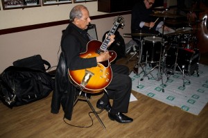 Phoenix Dixieland Jazz Band at Farnborough Jazz Club, 5th December 2015.  Ernie Cronenburgh (guitar).  No, he hasn't got black lips - he has a plectrum in his mouth!  Photo by Mike Witt.