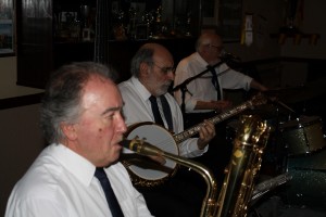 The engine: MICK SCRIVEN (bass sax), JOHN STEWART (bnj), and ARTHUR FRYATT (drms) of NAPIER HOTSHOTS at Farnborough Jazz Club, 16th January 2015. Photo by Mike Witt.