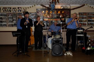 George Tidiman's All Stars Christmas Cracker Party, Farnborough Jazz Club, 19th December 2014. (ltoR) JOHN SIRETT (d.bass) TIM HUSKISSON (clarinet), DENNY ISLET (trumpet), BILL FINCH (drums), GEORGE TIDIMAN (trombone) and ‘SOUTHEND BOB’ ALBUTT (banjo)