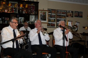 Front line MIKE JACKSON (trmpt), MIKE DUCKWORTH (trmb), PAT GLOVER (reeds) (plus ARTHUR FRYATT (drms) of NAPIER HOTSHOTS at Farnborough Jazz Club, 16th January 2015. Photo by Mike Witt.