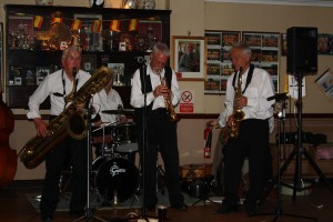 JOHN BAYNE plays 'Elephant Stomp' on baratone sax accompanied by MAX EMMONS on trumpet and BERNIE HOLDEN on alto sax with the Bob Dwyer's Bix & Pieces at Farnborough Jazz Club (Kent). 1st May 2015. Photo by Mike Witt.