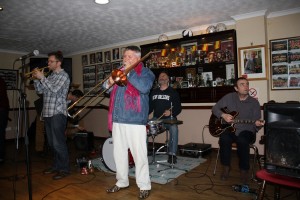 Martyn Brothers Jazz Band. Ben & Emile Martyn (d.bass & drums), Alan Beechey (trumpet), Jeff Williams -note his famous boots (trombone), Adrian Cox (clarinet), & JOHN ‘flashback radio’ RUSCOE (guitar) at Farnborough Jazz Club, Kent on 3rd April 2015. Photo by Mike Witt.