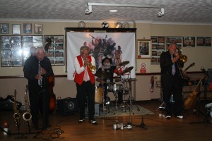 Dave Rance's Rockin' Chair Band at Farnborough Jazz Club (Kent) on 12th June 2015.(LtoR) Mike Brewerton (d.bass), Derek Scofield (reeds), Dave Rance (trmp), Henry Harrison (drms), Brian Webb (trmb) and (hidden) Doug Parry (bnjo). Photo by Mike Witt.