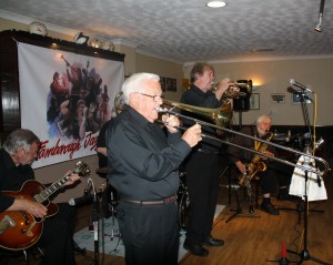 Laurie Chescoe's Reunion Jazz Band at Farnborough JC 3jul2015. (LtoR) Jim Douglas (guitar), Jackie Free (trmb), Alan (‘Lord Arsenal’) Bradley (trmp) and John Lee (tenor sax). Photo by Mike Witt.