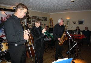 'Front line' of Phoenix Dixieland Jazz Band are pictured here at Farnborough Jazz Club on 23rd October 2015. (LtoR) Bill Todd (trombone), Paul Higgs (trumpet) and . Charles Sherwood (tenor sax). Founder of the band, Robin Coombs & wife Pauline are enjoying watching. Photo by Mike Witt.