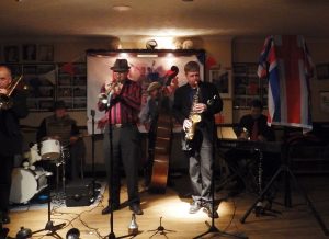 Hershey and the Hotshots play for the first time at Farnborough Jazz Club on 4th December 2015. (LtoR) Paul Taylor (trombone), Graham Collicott (drums), Peter Leonard (trumpet&vocs), Roger Curphey (double bass), Tim Huskisson (clarinet&alto sax) and Andrew Clancy (piano). Photo by Jill Alexander.