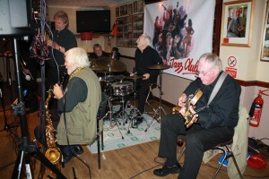 Laurie Chescoe's Reunion Band at Farnborough Jazz Club (Kent) on 4th September 2015. (LtoR) Allan 'Lord Arsenal' Bradley (trumpet), John Lee (reeds), Jim Douglas (guitar/banjo), Laurie Chescoe (drums), Peter Skivington, (bass guitar&bass ukelele). Photo By Mike Witt.
