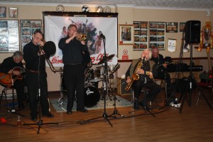 Laurie Chescoe's Reunion Band at Farnborough Jazz Club (Kent) on 4th September 2015. (LtoR) Jim Douglas (guitar/banjo), Mike Pointon (trombone), Allan 'Lord Arsenal' Bradley (trumpet), Laurie Chescoe- hidden (drums), John Lee (reeds) Peter Skivington (bass-guitar/bass ukelele). Photo By Mike Witt.