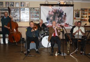 'Bill Phelan's Muscrat Ramblers' at Farnborough Jazz Club (Kent) on 27th May 2016. (LtoR) Andy Lawrence (double bass), John Finch (trombone &vocals), Paul Norman (drums), Bill Phelan (band leader, trurmpet & Flugabone), Johnny McCallum (banjo & guitar) and Alan Cresswell (clarinet), Photo by Mike Witt.