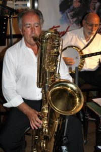 Mick Scriven plays bass sax (big bertha as I call it) with John Stewart on banjo, seen here at Farnborough Jazz Club (Kent). With Lord Napier Hotshots on Friday 29th July 2016. Photo by Mike Witt