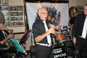 Dennis Vick takes a solo, whilst Dave Marchant looks on. (LtoR) Dave Arnold (Sousaphone), Dennis Vick, Ken Joiner (drums), Dave Marchant and Brian Vick (banjo), plus( not in view) John Lee (trombone), members of The Fenny Stompers at Farnborough Jazz Club's 'Battle of Brittain' Anniversary fancy dress party on 16th September 2016. Photo by Mike Witt.
