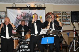 Dennis Vick (clarinet), Ken Joiner (drums), Dave Marchant (trumpet) and John Lee (trombone) both playing the maracas, with Brian Vick (banjo) and out of view Dave Arnold (Sousaphone) members of The Fenny Stompers at Farnborough Jazz Club's 'Battle of Britain' Anniversary fancy dress party on 16th September 2016. Photo by Mike Witt.